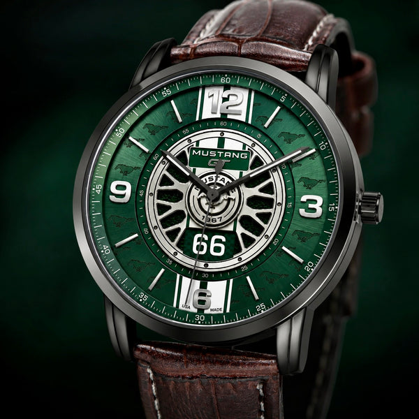 A close-up of a wristwatch with a green dial, silver-tone inner ring, white numerals, and a brown leather strap on a dark green background.
