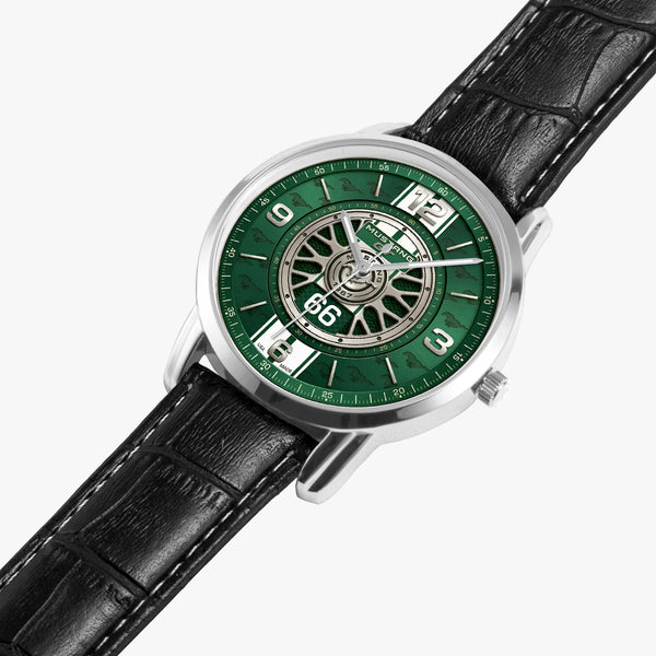 A wristwatch with a green dial featuring a vintage wheel design and silver-tone case, paired with a black leather strap on a light gray background.