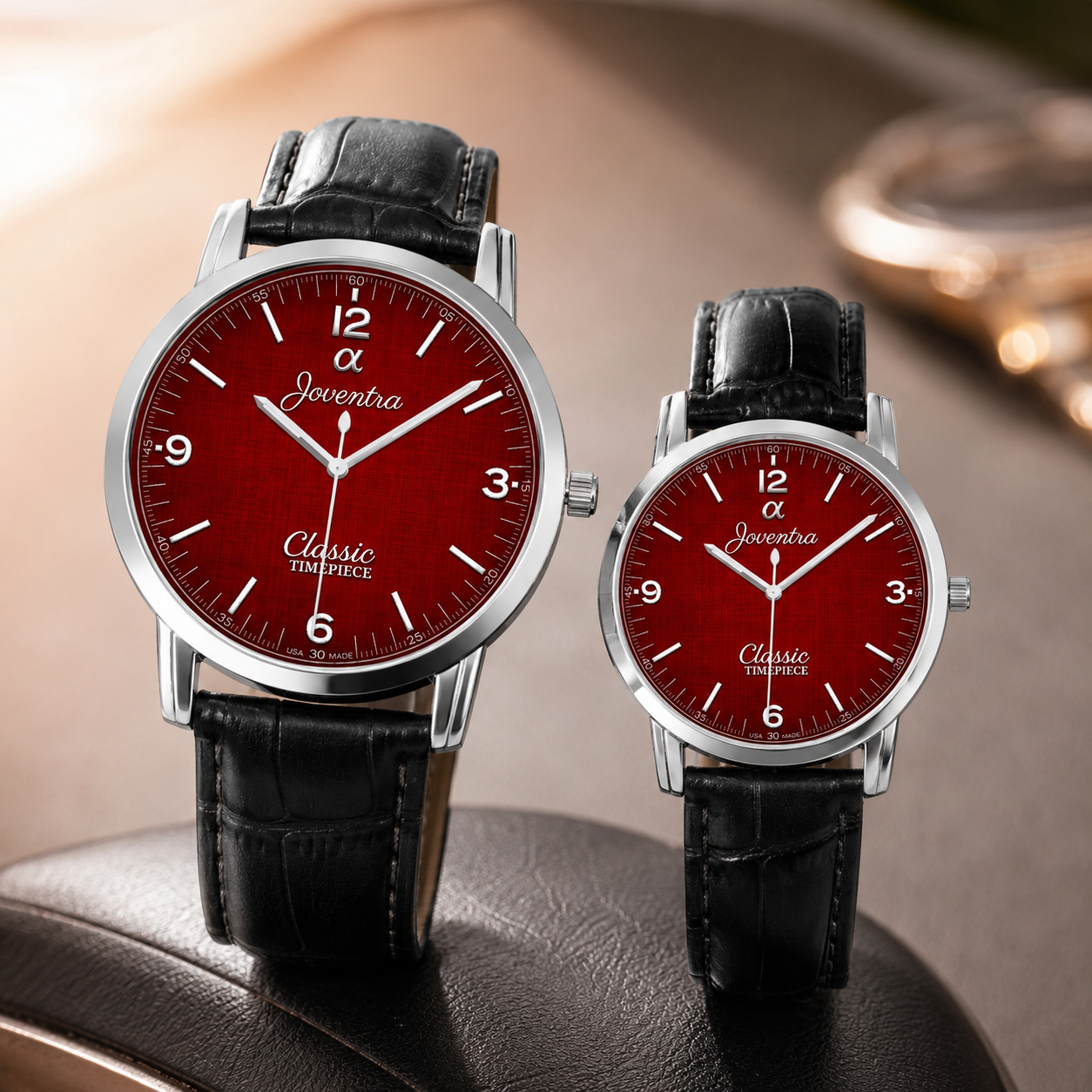 Two silver-tone Jeventra Classic Tissot watches with red dials and black alligator leather straps, displayed on a dark leather surface with a warm blurred background.