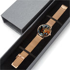 A wristwatch with a rose gold mesh strap and a colorful abstract round dial, presented inside a black gift box next to its gray outer packaging.