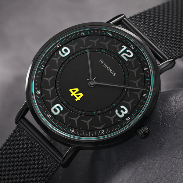 A Petronas wristwatch with a black round case, black mesh strap, and a black dial featuring white Arabic numerals and a bright yellow '44' at the 6 o'clock position.