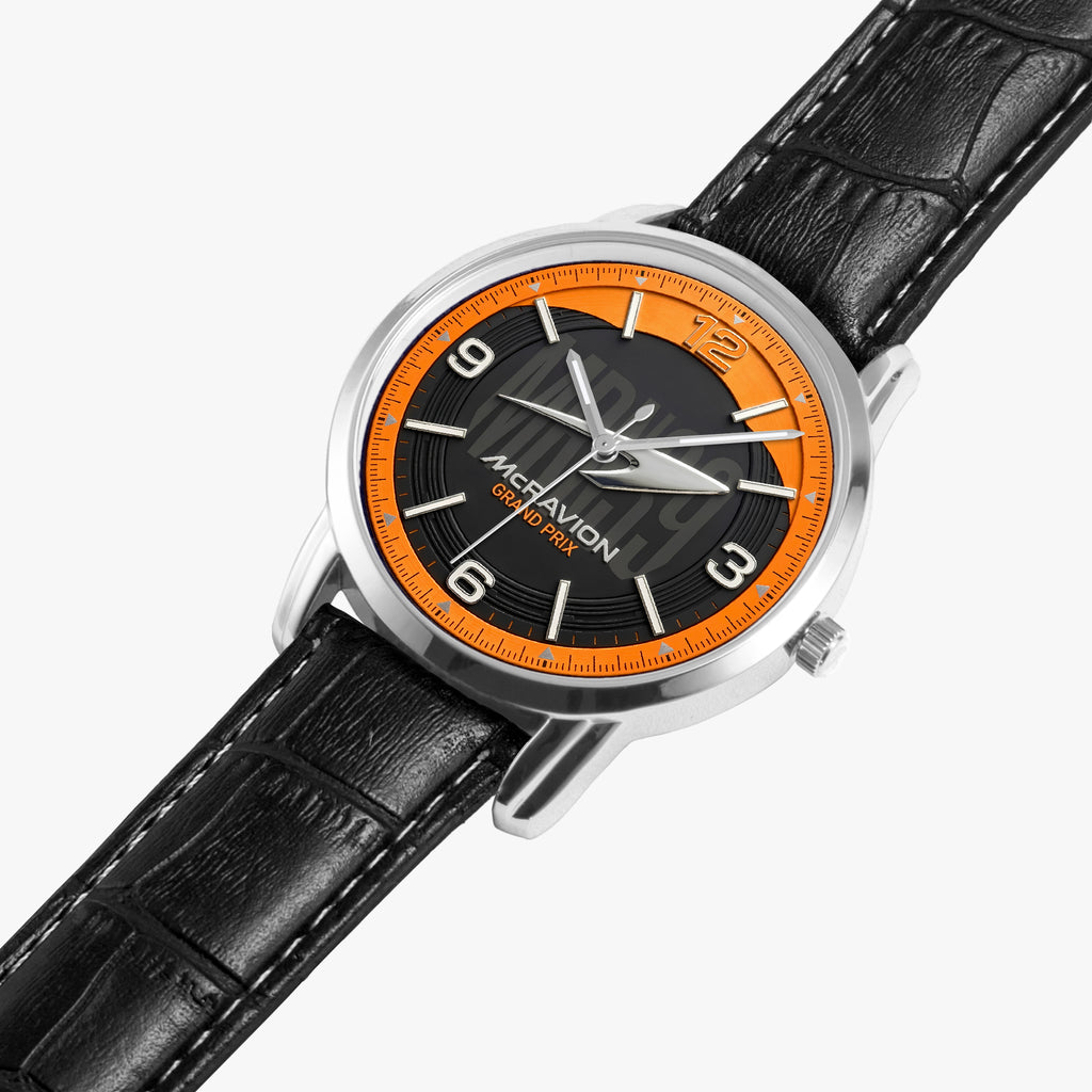 A wristwatch with a black leather strap, a silver-toned case, and a black dial featuring a bright orange ring around the bezel. The brand name 'MCRAVION' is printed on the dial.