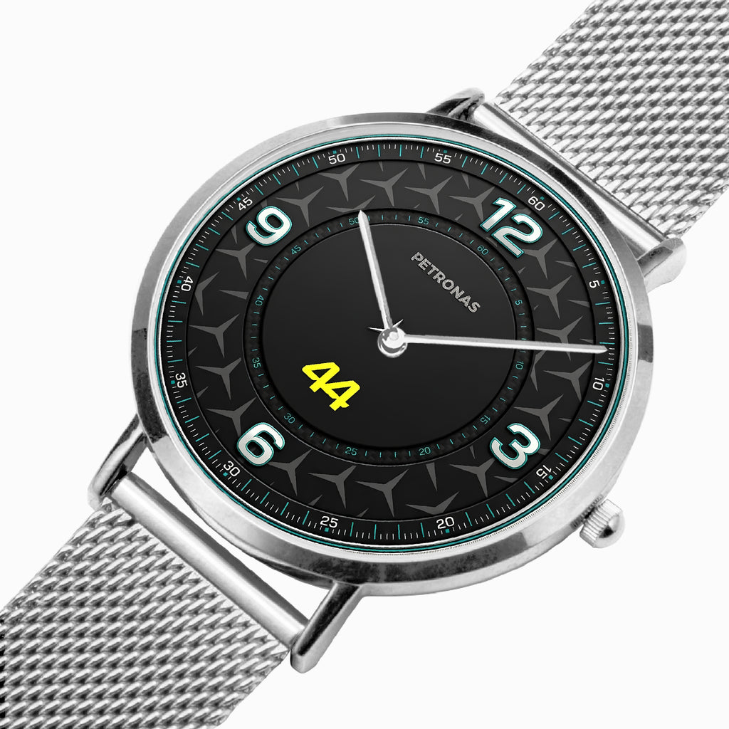 A Petronas wristwatch with a silver stainless steel mesh strap and a black dial featuring a star pattern, white Arabic numerals, and a bright yellow '44' on the center.