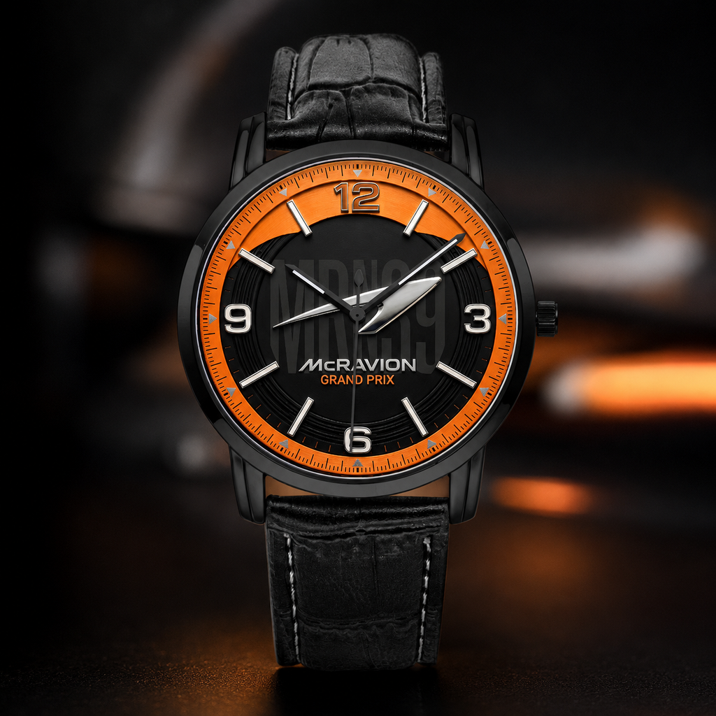 A luxury wristwatch with a black round case, a black dial featuring a bright orange inner ring and white Arabic numerals, and a black crocodile-embossed leather strap, set against a dark, moody background with warm orange highlights.