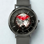 A dark gray metal mesh-strand bracelet watch with a round case and a highly detailed graphic dial. The dial features a black background with a glowing red bat emblem at the 12 o'clock position, a central white and gray cloud-like pattern, and a dark figure at the bottom.