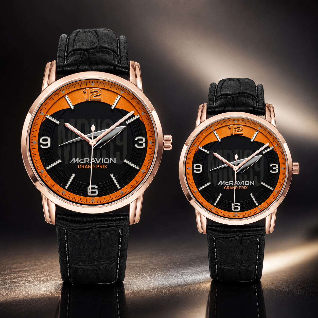 Two McRivion Grand Prix analog wristwatches with black leather straps, rose gold cases, and black dials with bright orange accents, displayed on a reflective dark surface.
