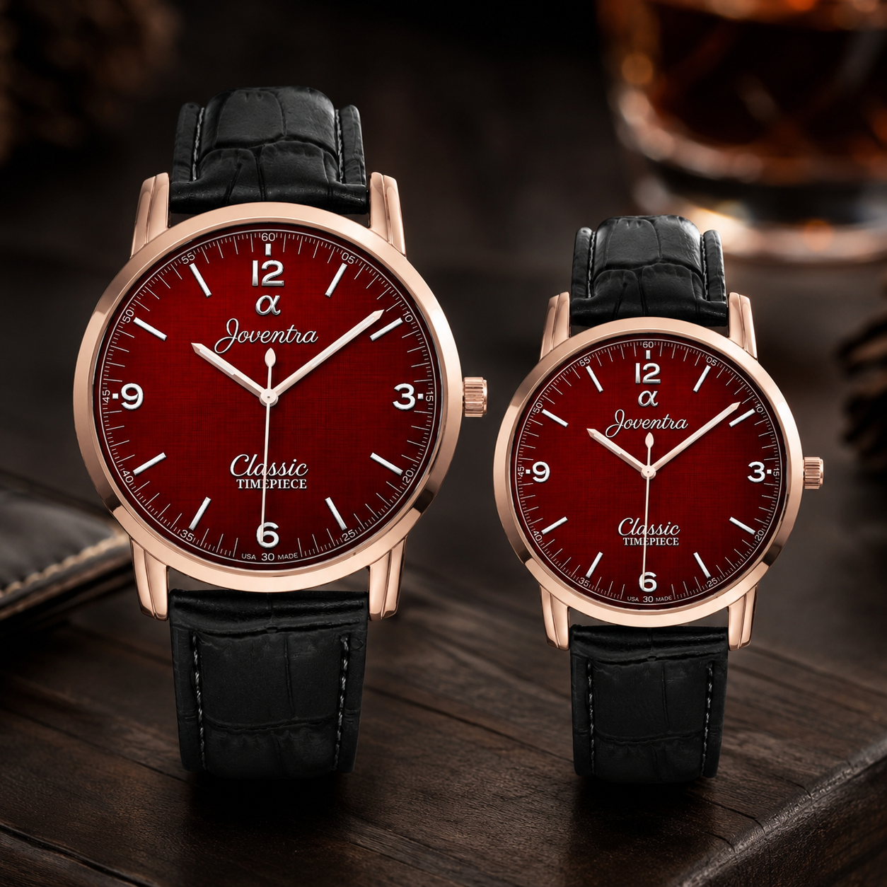 Two matching Joventia Classic Empiece wristwatches with rose gold cases, deep red dials, and black leather straps, displayed on a dark wooden surface.