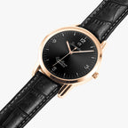 A luxury wristwatch with a round black dial, rose gold case, and a black leather strap with white stitching, shown on a light gray background.