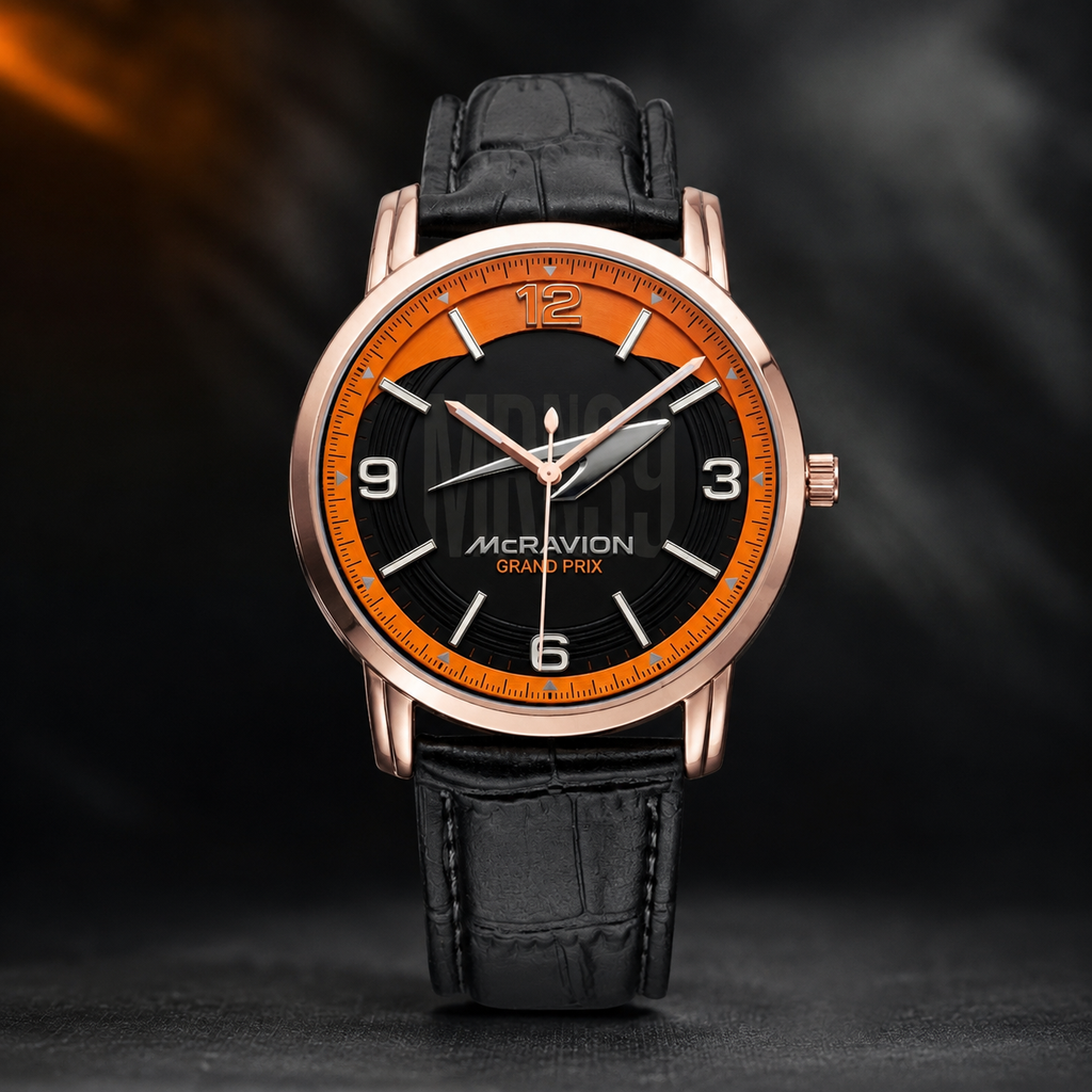 A men's wristwatch with a black leather strap, a black dial, and a vibrant orange ring around the bezel and dial. The watch case is rose gold-tone metal.