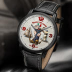 A close-up of a wristwatch with a black leather strap and a detailed Popeye the Sailor themed dial, resting on a dark textured surface.