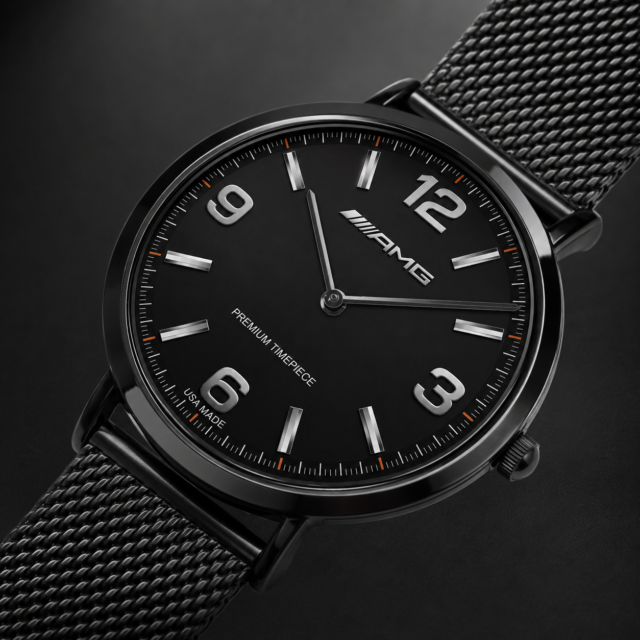 A close-up studio shot of a black Mercedes-AMG wristwatch with a black mesh metal band, featuring silver-tone numerals and hands with subtle orange accents on the dial.