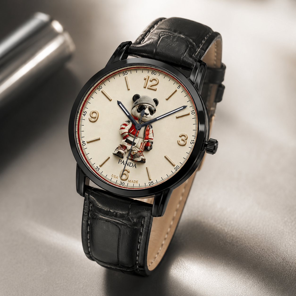 A wristwatch with a black leather strap, black case, and a cream-colored dial featuring a cartoon panda character. The watch is photographed on a reflective metallic surface.