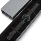 Watch with black mesh strap in a gray box on a white background