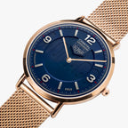 A close-up of an Orbital watch featuring a deep blue dial, gold-tone case, and a matching gold-tone mesh strap on a light gray background.