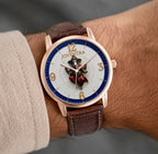 A close-up of a Joventra wristwatch with a rose gold case, brown leather strap, and a white dial featuring a central knight emblem, shown worn on a person's wrist.