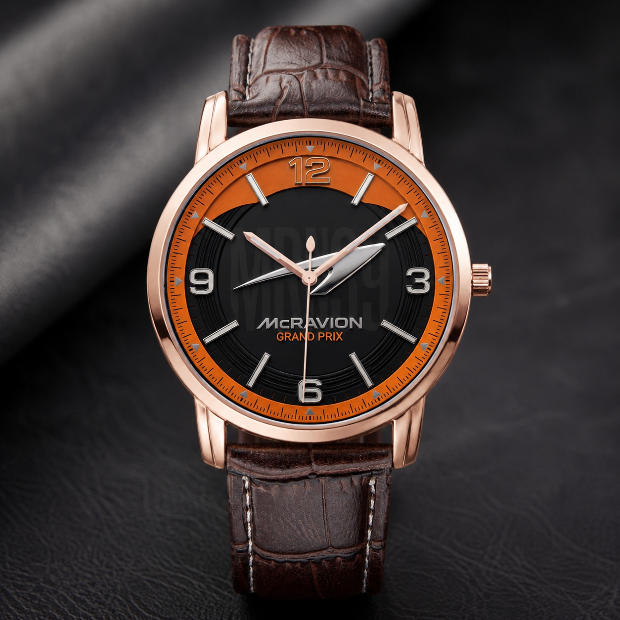 Joventra McRavion Grand Prix unisex racing watch in a rose gold stainless steel case with a black and orange racing dial and brown textured leather strap.