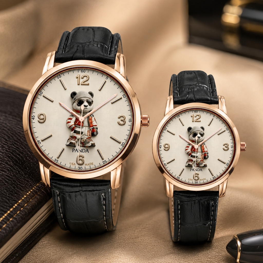 Two matching wristwatches with rose gold cases, black leather straps, and cream dials featuring a panda character, displayed on a beige fabric surface with a book and pen as props.