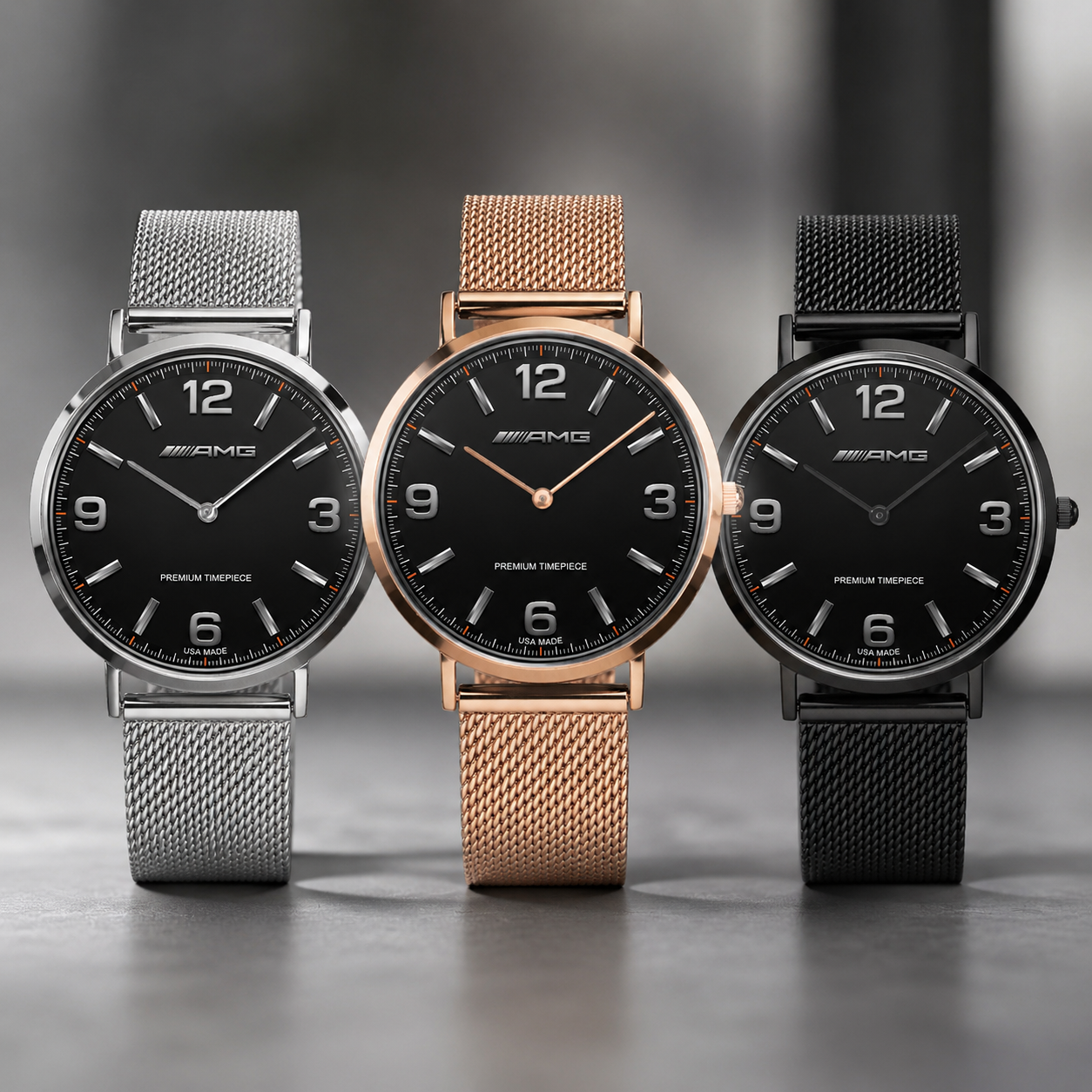 Three Mercedes-Benz wristwatches with black dials and mesh straps are lined up on a gray surface. The watches have silver, rose gold, and black metal cases and mesh bands.