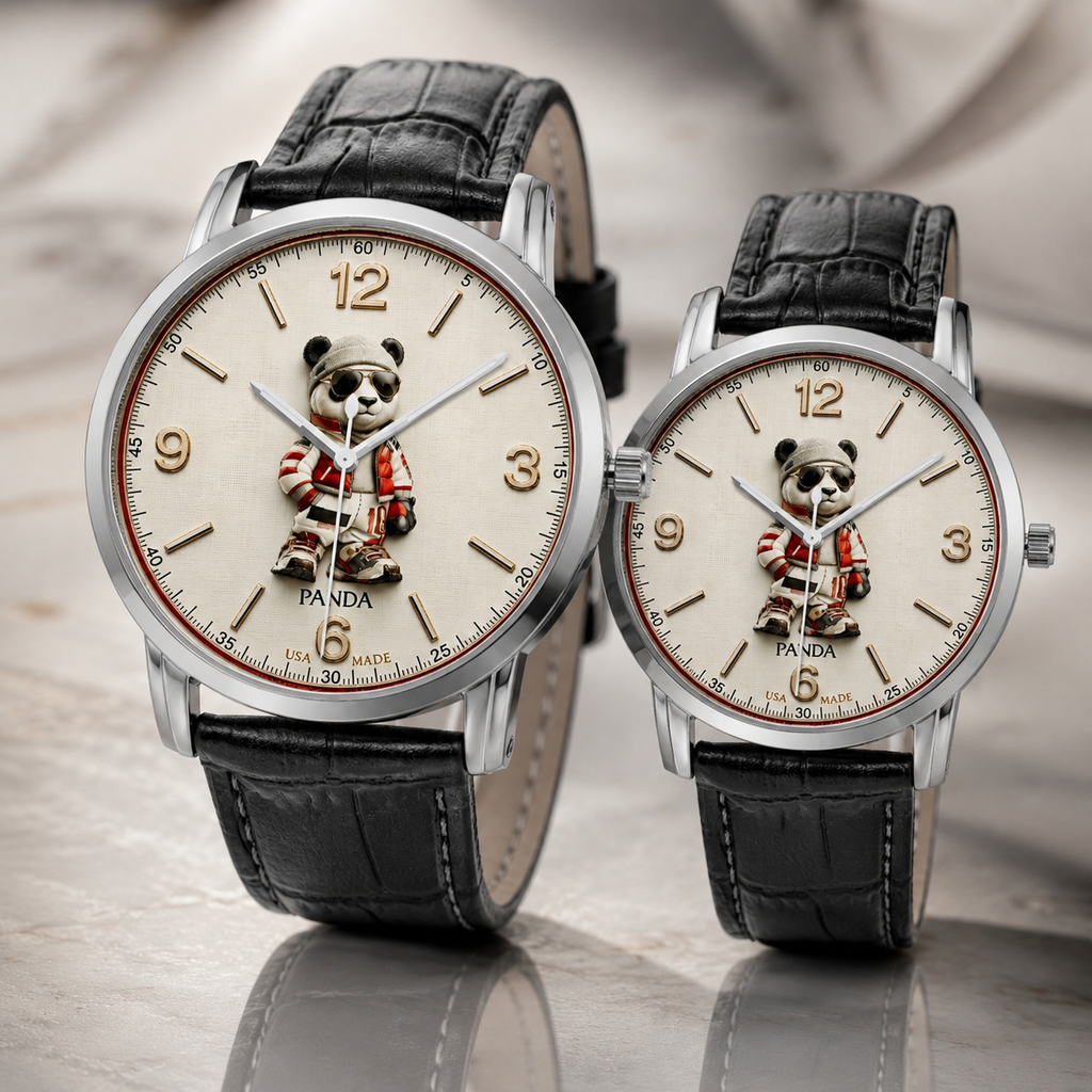 Two matching wristwatches with round silver-tone cases, cream-colored dials featuring a panda illustration, and black leather straps, displayed on a reflective surface.