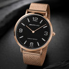 A luxury watch with a black dial, rose gold case, and matching rose gold mesh strap, featuring the AMG logo on the dial, set against a dark textured background.